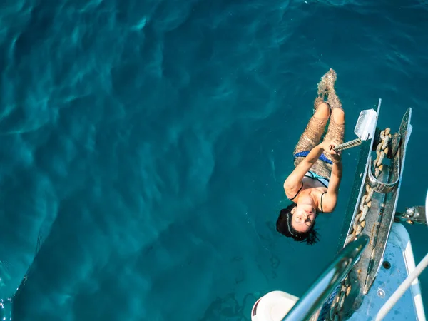 Jeune femme en bikini bleu accroché à la chaîne d'ancrage — Photo