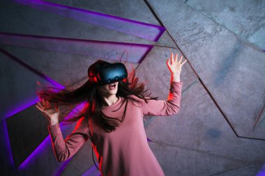 Dikkat et. Vr gözlüklü ve çırpınan saçları olan genç kadın aktif tepki veriyor, oyunda olanlardan korkuyor.