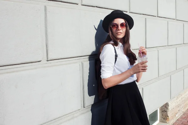 Una joven con sombrero caminando por la ciudad. Chica turística disfruta de la caminata . —  Fotos de Stock