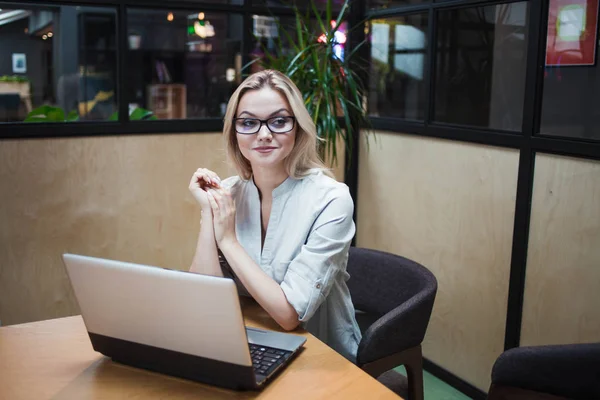 Egy irodai dolgozó vagy diák egy laptopon dolgozik. Boldog magabiztos szőke egy elegáns irodában. — Stock Fotó