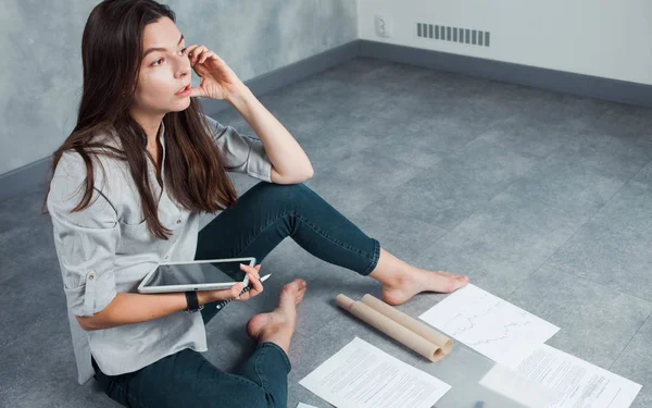 Jonge vrouwelijke freelancer en ondernemer werkt aan een project op de vloer. — Stockfoto