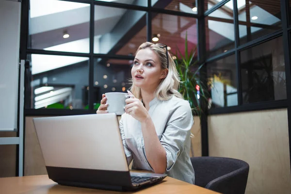 Jovem mulher confiante trabalhando em um laptop no escritório . — Fotografia de Stock