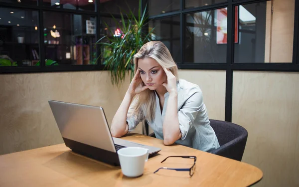 Cansado de excesso de trabalho jovem no escritório no laptop — Fotografia de Stock