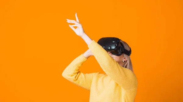 Computer game speler maakt gebruik van virtual reality. Een jonge vrouw in een virtual reality helm — Stockfoto