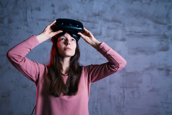 Short break. A delighted girl holds virtual reality glasses on her forehead. She takes off, opens her face.