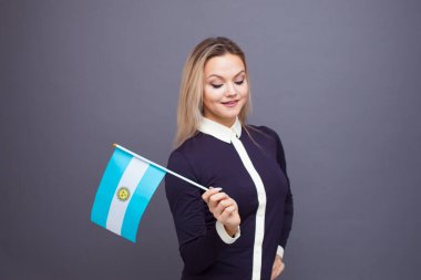 Göçmenlik ve yabancı dil eğitimi, konsept. Elinde Arjantin bayrağı olan gülümseyen genç bir kadın..