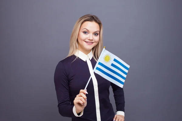 Immigrazione e studio delle lingue straniere, concetto. Una giovane donna sorridente con una bandiera dell'Uruguay in mano. — Foto Stock