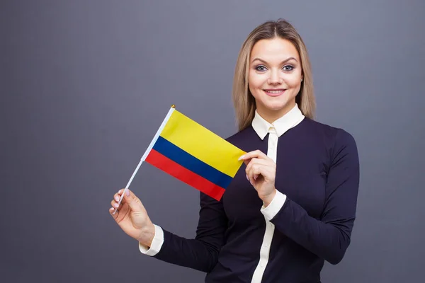 Inmigración y el estudio de lenguas extranjeras, concepto. Una joven sonriente con una bandera de Colombia en la mano . — Foto de Stock