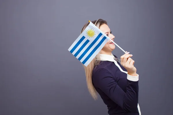 Imigrace a studium cizích jazyků, koncepce. Mladá usměvavá žena s uruguayskou vlajkou v ruce. — Stock fotografie