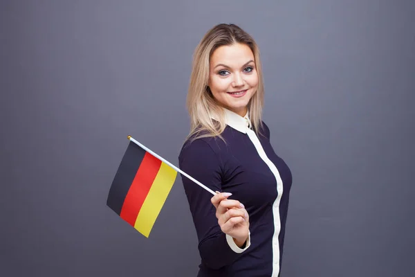 Imigrasi dan studi bahasa asing, konsep. Seorang wanita muda tersenyum dengan bendera Jerman di tangannya. — Stok Foto