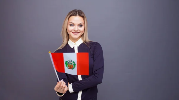 Invandring och studier av främmande språk, begrepp. En ung leende kvinna med Perus flagga i handen — Stockfoto