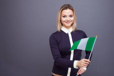 Göçmenlik ve yabancı dil eğitimi, konsept. Elinde Nijerya bayrağı olan gülümseyen genç bir kadın..