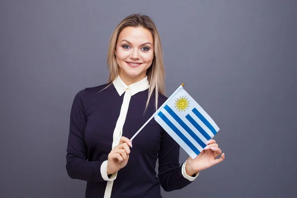 Μετανάστευση και μελέτη ξένων γλωσσών, έννοια. Μια νεαρή χαμογελαστή γυναίκα με μια σημαία της Ουρουγουάης στο χέρι της. — Φωτογραφία Αρχείου