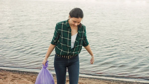 Uklízení odpadků, dobrovolnická práce. Starat se o přírodu. Lidé nechali na pláži spoustu plastových odpadků. — Stock fotografie