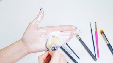 Makyaj fırçalarının temizlenmesi ve bakımı, kadınların elleri kozmetik ürünlerinin fırçasını yıkar.,