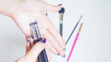 Makyaj fırçalarının temizlenmesi ve bakımı, kadınların elleri kozmetik ürünlerinin fırçasını yıkar.,