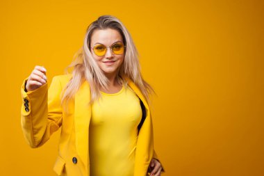 Dans eden ve neşe saçan zarif genç bir kadın. Sarı ceketli kız.