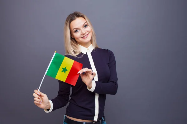 Invandring och studier av främmande språk, begrepp. En ung leende kvinna med en Senegal flagga i handen — Stockfoto