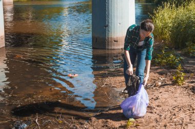Çöpleri temizlemek, gönüllü iş. Doğayı önemsemek. İnsanlar plaja bir sürü plastik çöp bırakmışlar.