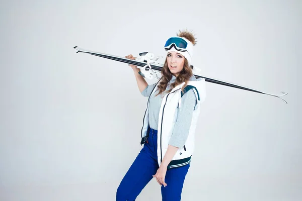 Skieuse souriante dans un chapeau et un masque pour skier. Une jeune femme vêtue pour le ski et les activités de plein air. — Photo