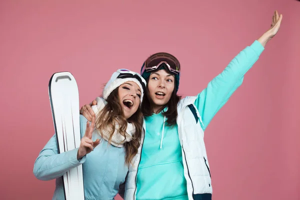 Deux drôles d'amis en vêtements d'hiver sur fond rose. Deux skieurs — Photo