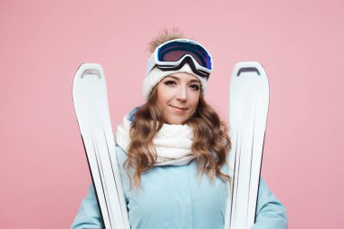 Neşeli genç bayan kayakçı kayak yapmaya hazırlanıyor. Ekipmanlı ve kayaklı bir kız.