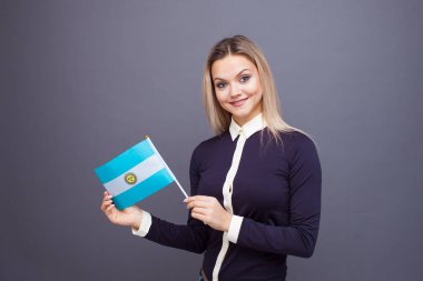 Göçmenlik ve yabancı dil eğitimi, konsept. Elinde Arjantin bayrağı olan gülümseyen genç bir kadın..