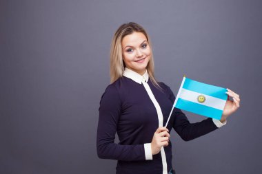 Göçmenlik ve yabancı dil eğitimi, konsept. Elinde Arjantin bayrağı olan gülümseyen genç bir kadın..