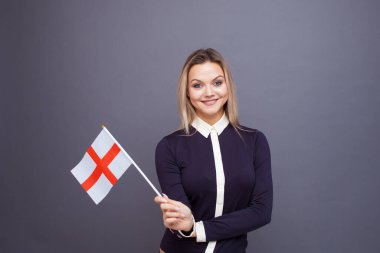 Göçmenlik ve yabancı dil eğitimi, konsept. Elinde İngiltere bayrağı olan gülümseyen genç bir kadın..