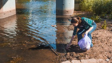 Çöpleri temizlemek, gönüllü iş. Doğayı önemsemek. İnsanlar plaja bir sürü plastik çöp bırakmışlar.