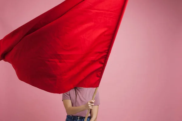 Aktivista és forradalmian új, fiatal nő piros zászlóval rózsaszín alapon. — Stock Fotó