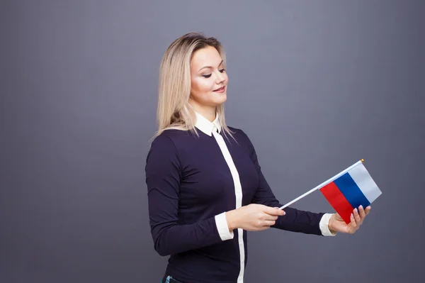 Иммиграция и изучение иностранных языков, концепция. Молодая улыбающаяся женщина с флагом России в руке. — стоковое фото