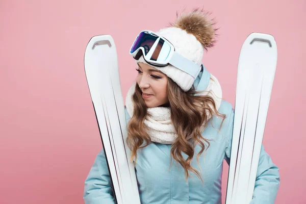 Весела позитивна молода лижниця готується кататися на лижах. Дівчина в обладнанні і з лижами — стокове фото