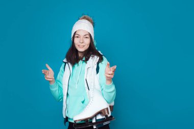 Kış hobisi, buz pateni. Kazaklı ve örgü şapkalı genç bir kadın.