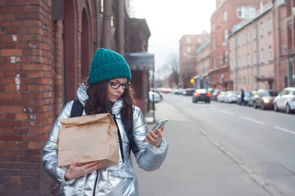 Essen zum Mitnehmen, eine junge Frau beim Einkaufen in einer umweltfreundlichen Papiertüte. — Stockfoto