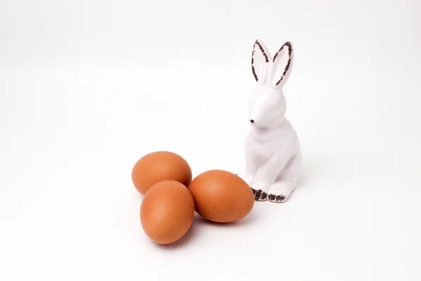Osterhase Keramikfigur drei Eier auf weißem Hintergrund — Stockfoto