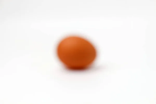 Brown one egg not painted on a white background isolated blurry — Stock Photo, Image