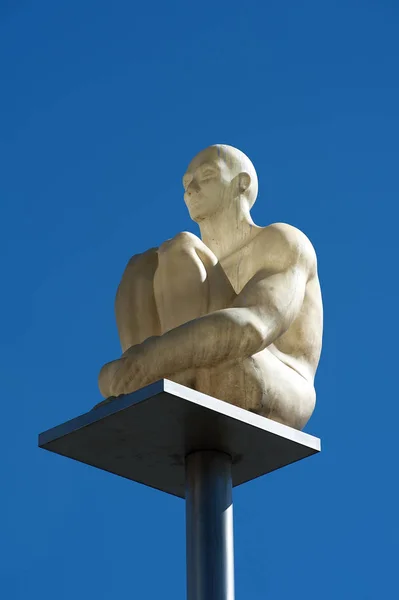 Bílá socha na kůlu na obloze — Stock fotografie