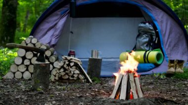 Yanan bir ateş ve günlükleri bir turist çadır arka planda yanmak.