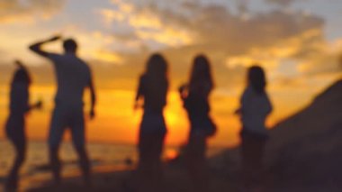 Grup günbatımı sırasında dans insan. Bulanık ağır çekim.