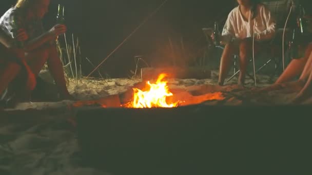 小组的朋友放松周围的篝火在海滩上和乐趣 — 图库视频影像