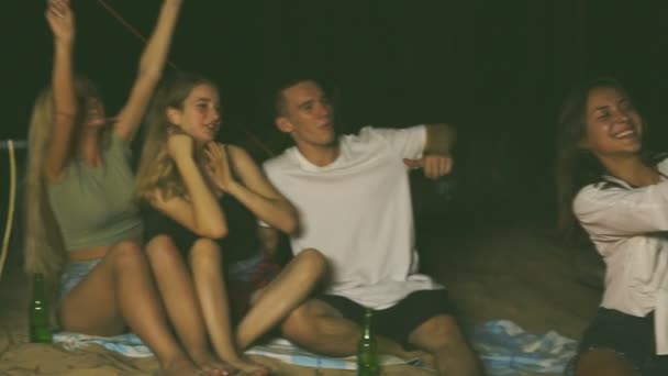 Grupo Amigos Relajándose Alrededor Hoguera Playa Divirtiéndose — Vídeo de stock