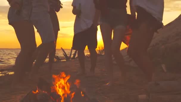 焚き火の近くのビーチで踊る人々 のグループ — ストック動画