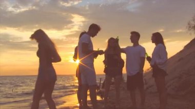 Arkadaşlar gün batımında deniz kenarında. Grup insanlar enjoing iyi zaman.