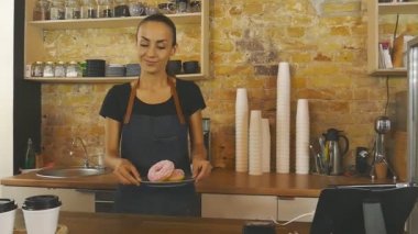 Fincan kahve ve donats müşteriye vererek garson gülümseyerek.