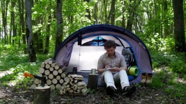 Backpacker bir defterde açık havada notlar alır. Doğada kamp.