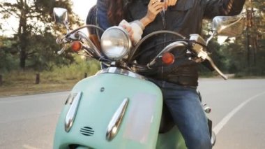 Scooter üzerinde oturan ve onlar sadece yapmış fotoğraf kartları üzerinde seyir genç çift.