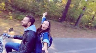 Mutlu çift ormandaki bir scooter sürme. Güneşli güzel bir gün. Selfie-stick kamera görüntüsü. Ağır çekim.