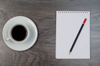 Defter, kahve ve ahşap masa üstünde smartphone.