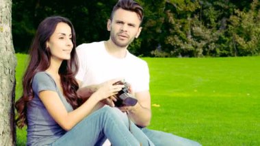 Mutlu çift yeşil çim üzerinde eski bir kamera ile fotoğraf çekmek.